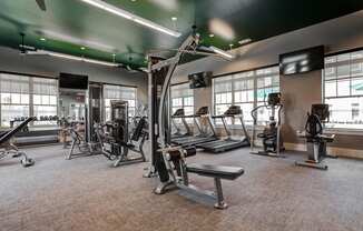 a large fitness room with treadmills and other exercise equipment