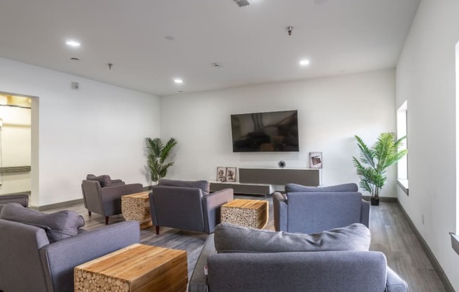 a living room with couches and chairs and a television on the wall