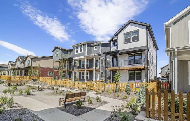 a group of townhomes with benches in a courtyard