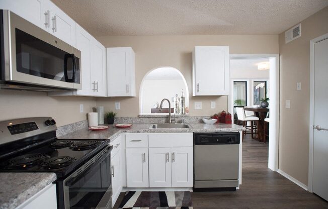 A kitchen with white cabinets and a black and white checkered floor at Ridge Crossings Apartments, Hoover, Alabama