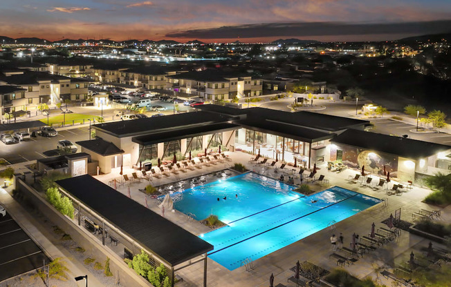 A large swimming pool surrounded by a covered area with people around it.