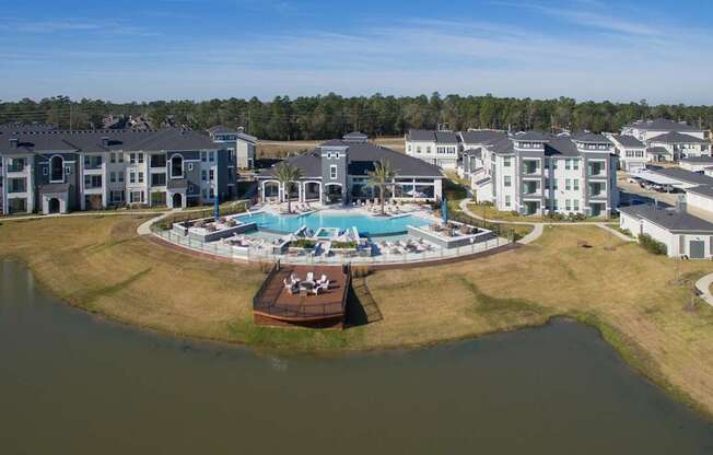 A large building complex with a pool and a small island in the middle of a lake.