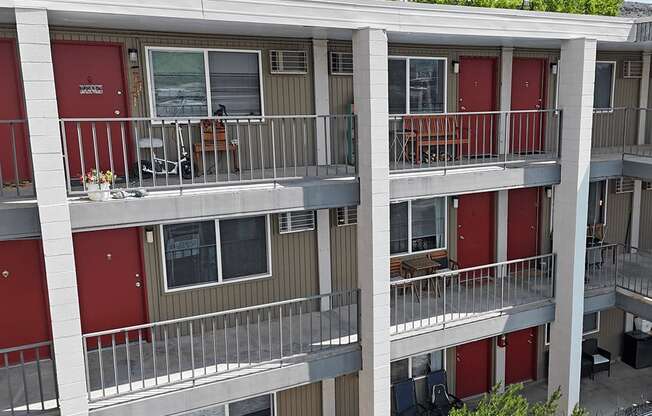 Apartment building with red doors and balconies.