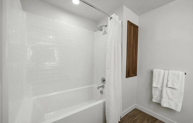 Bathroom with shower and curtain at Bayview Apartments, Emeryville, 94608