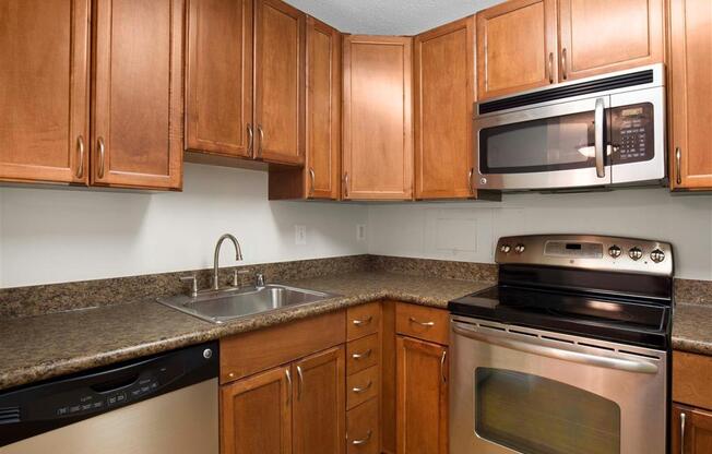 Kitchen with Brown Cabinets Stainless Steel Appliances and Grey Counters and Breakfast Bar with Decorative Items
