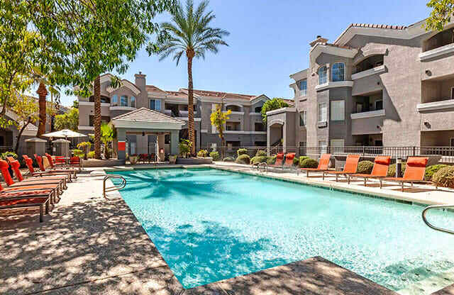 The Highland Apartments Pool during daylight with orange lounge chairs