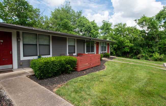 A red door is on the left side of a grey building at The Retreat at Indian Lake Apartments in Hendersonville TN.