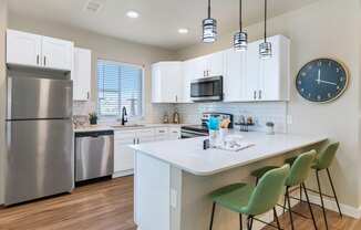 a kitchen with stainless steel appliances and a quartz counter topat Solace at Ballpark Village, Goodyear, Arizona