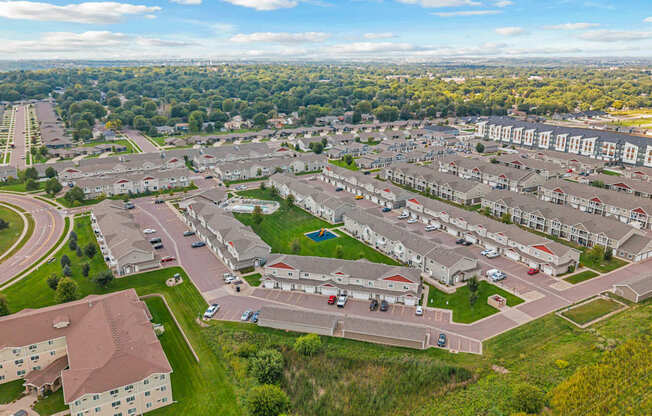 A bird's eye view of a residential area with multiple houses and a parking lot.