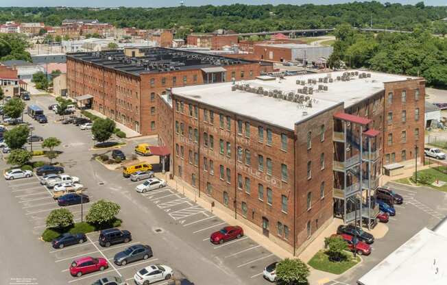 an aerial view of an apartment building in a parking lot at Mayton Transfer Lofts, Petersburg, 23803