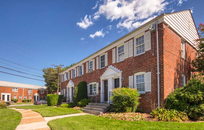 A red brick building with white trim and a white door.
