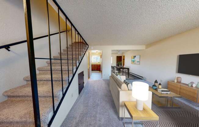 a living room with a staircase and a tv