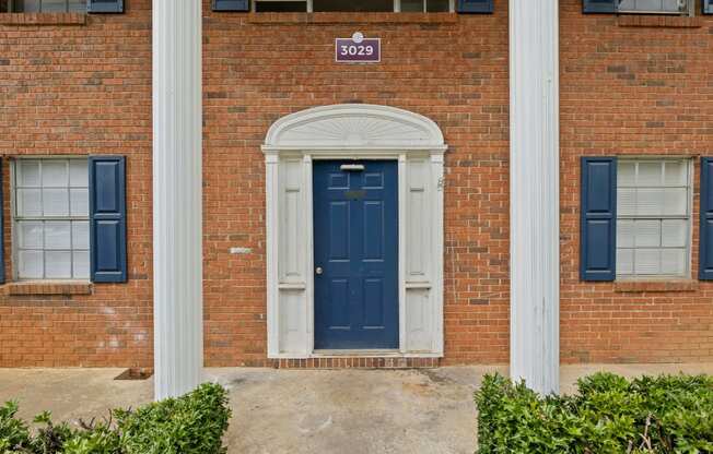 the front of a brick building with a blue door