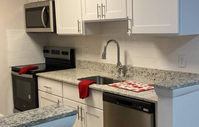 a kitchen with white cabinets and granite counter tops