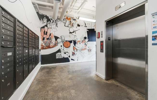 a hallway with lockers and a mural on the wall and a door