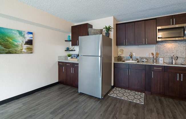 Waikiki Walina Apartments kitchen area with appliances, cabinets, and counters