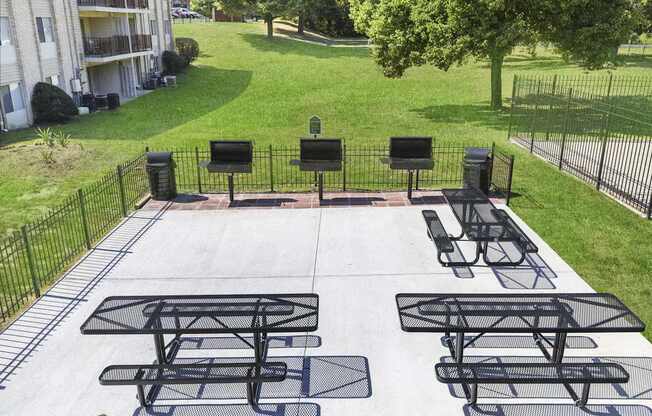 A black metal table and chairs are set up on a concrete patio.