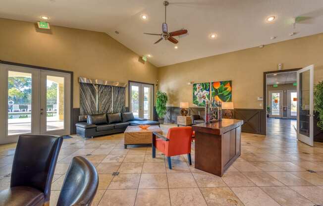a large living room with a table and chairs and a ceiling fan
