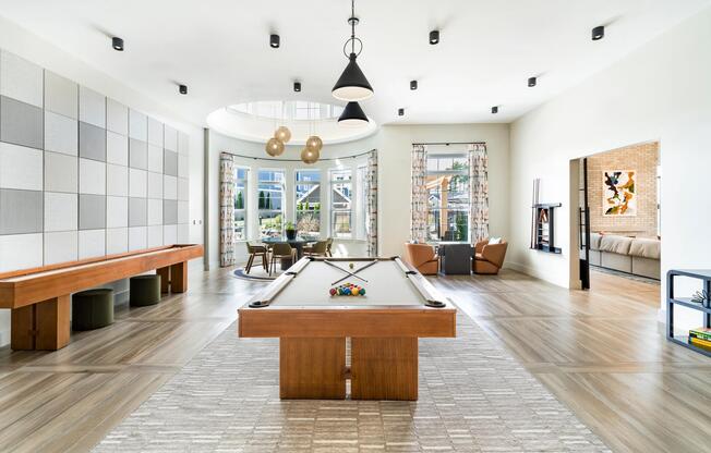 The resident lounge offers an inviting mix of seating areas, a billiards table, and shuffleboard—perfect for relaxing or hosting friends.