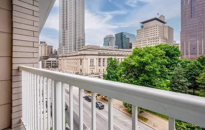 the view of the city from a balcony with a white railing