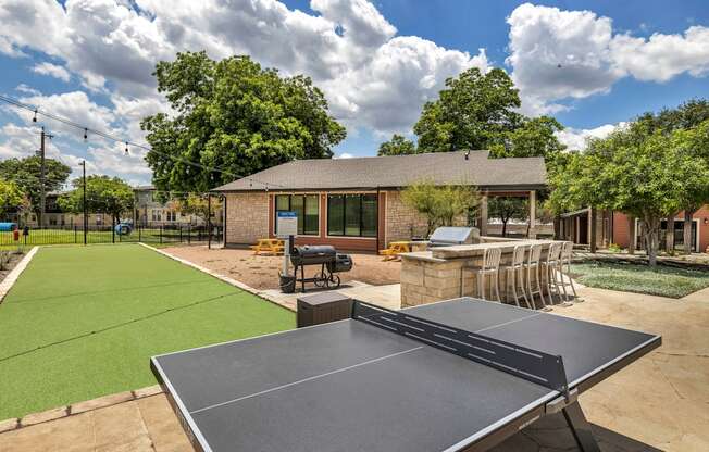 a tennis court and ping pong table in the backyard of a home  at Sunset Ridge, San Antonio