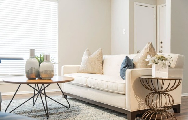 a living room with a couch and tables