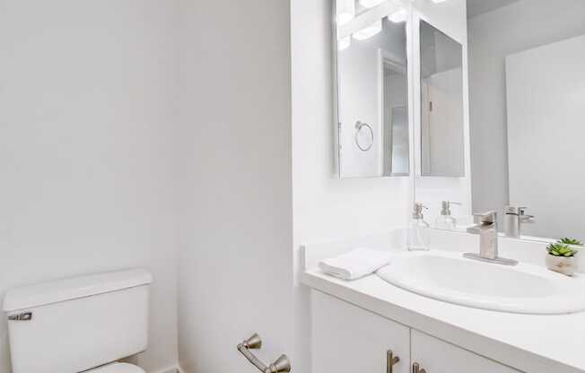 A white toilet sits next to a white sink in a bathroom.