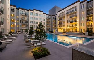 an apartment building with a swimming pool at night