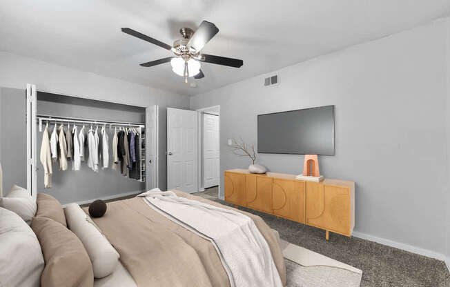 Pet-Friendly Apartments in Overland Park– Treetop Lodge – A bedroom with a bed, a TV, and a wardrobe.