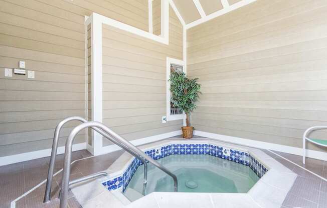 A hot tub in a room with wooden walls.