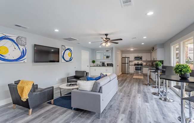 an open living room and kitchen with couches and a tv