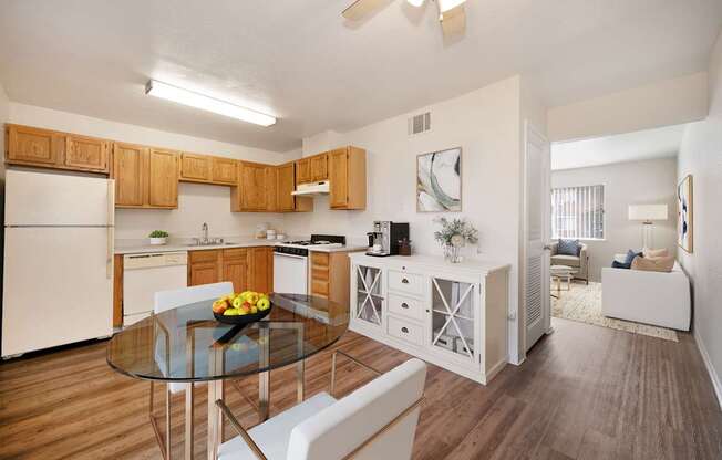 A modern kitchen with wooden cabinets and a glass table.