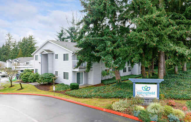 a white house with a sign and trees at Springfield, Renton, WA