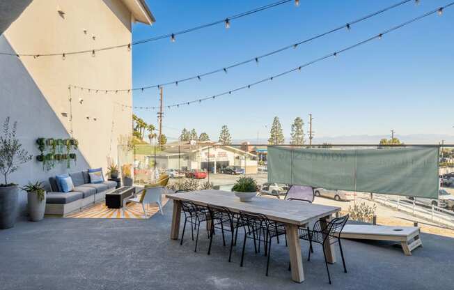 a patio with a table and chairs under string lights