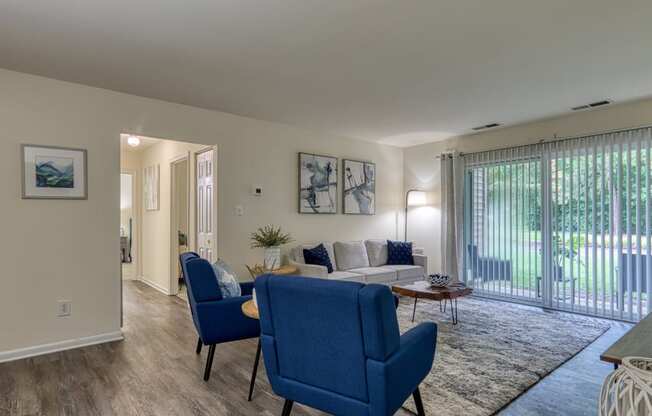 a living room with a couch and chairs and a sliding glass door