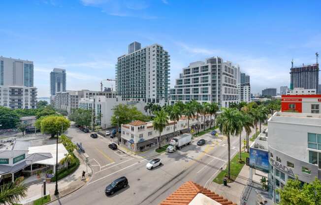 an aerial view of a city street with tall buildings and palm trees