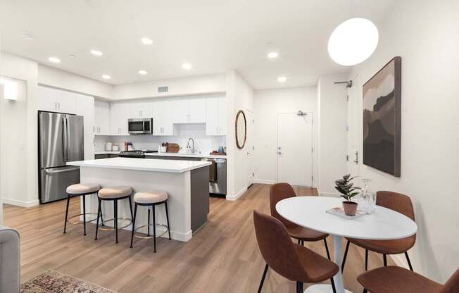A modern kitchen with a bar area and a dining table set up at The Villas at Anacapa Canyon, Camarillo, 93012