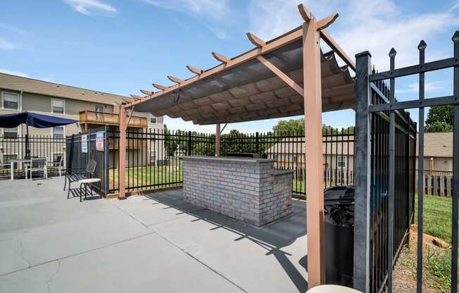 the clubhouse has a patio with a brick fireplace and a gazebo