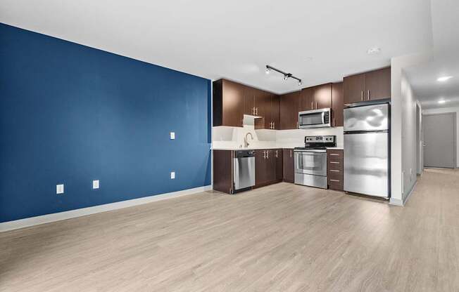 A kitchen with blue walls and wooden floors.