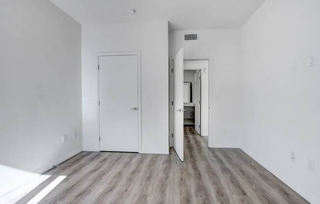 an empty living room with white walls and wood floors