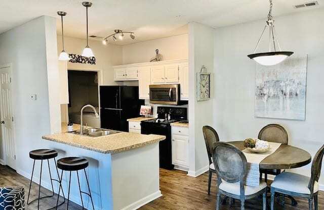 A kitchen with a bar and a dining table.