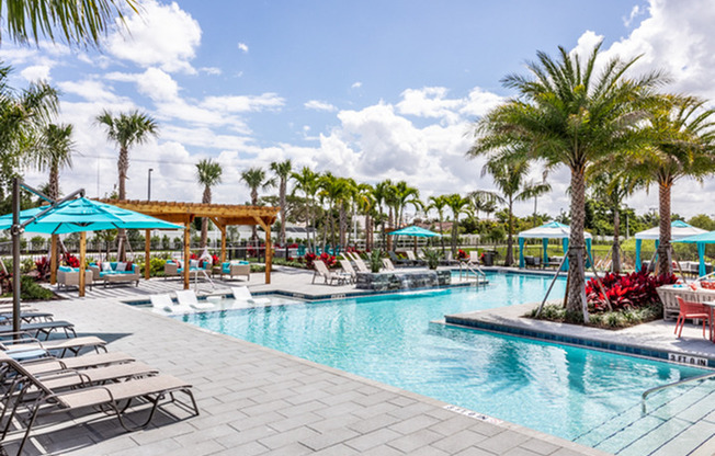 exterior pool with patio furniture and palm trees on sunny day