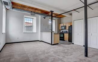 an empty living room and kitchen in a loft