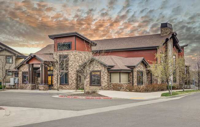 the front of a house with a cloudy sky in the background