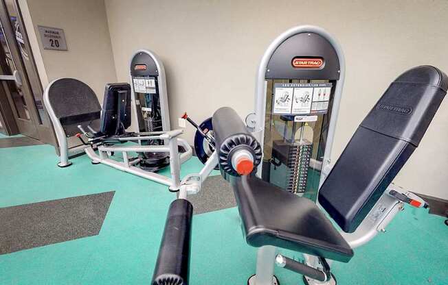 A gym with a row of exercise machines including a leg press machine.