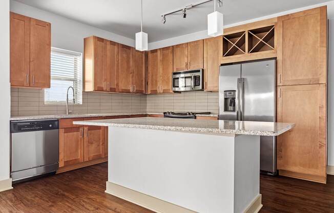 A kitchen with wooden cabinets and a white island.