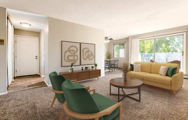 a living room with a yellow couch and green chairs