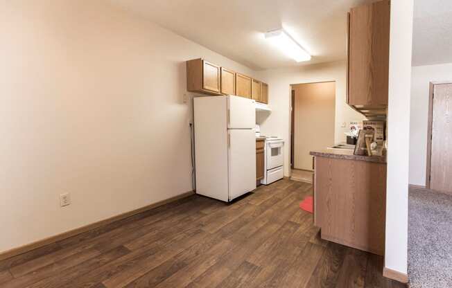 Grand Forks, ND Cherry Creek Apartments. A bedroom in unit 223 that has a window, white walls, and carpeted floors