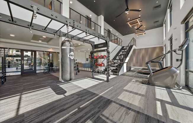 A gym with a variety of equipment including a treadmill, weights, and a pull up bar.