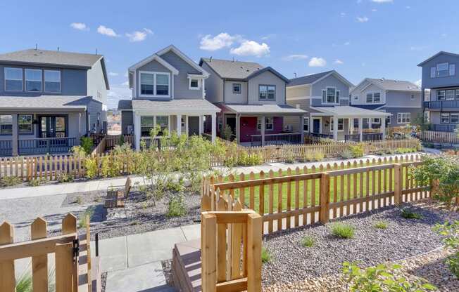 a row of houses with a yard and a wooden fence